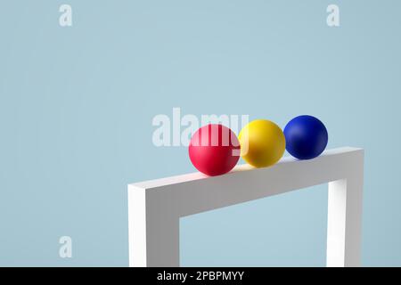 Sfere colorate in una riga che bilanciano su una cornice vuota. Vita morta minimalista astratta con oggetti geometrici. rendering 3d. Foto Stock