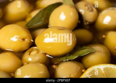 Olive farcite al formaggio. Pila di olive verdi con olio d'oliva e spezie Foto Stock