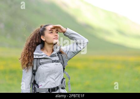 Escursionista alla ricerca con mano sulla fronte in natura Foto Stock