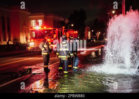 Alameda, Stati Uniti. 12th Mar, 2023. I vigili del fuoco lavorano sull'idrante. Un idrante antincendio situato sulla strada a Central Ave in Alameda, California, è stato schiacciato da un'auto il 12 marzo. L'acqua sotto l'idrante del fuoco uscì e allagò la strada. I vigili del fuoco dell'Alameda hanno risposto per risolvere questo problema e hanno impedito all'acqua di uscire. Credit: SOPA Images Limited/Alamy Live News Foto Stock