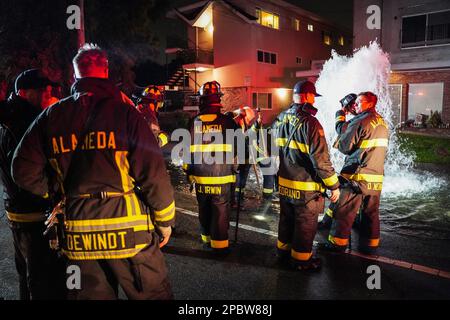 Alameda, Stati Uniti. 12th Mar, 2023. I vigili del fuoco discutono la soluzione su come fermare l'acqua. Un idrante antincendio situato sulla strada a Central Ave in Alameda, California, è stato schiacciato da un'auto il 12 marzo. L'acqua sotto l'idrante del fuoco uscì e allagò la strada. I vigili del fuoco dell'Alameda hanno risposto per risolvere questo problema e hanno impedito all'acqua di uscire. Credit: SOPA Images Limited/Alamy Live News Foto Stock