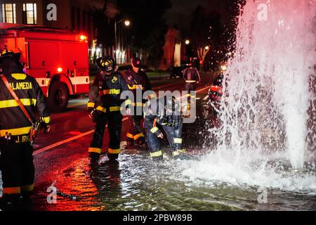 Alameda, Stati Uniti. 12th Mar, 2023. I vigili del fuoco lavorano sull'idrante. Un idrante antincendio situato sulla strada a Central Ave in Alameda, California, è stato schiacciato da un'auto il 12 marzo. L'acqua sotto l'idrante del fuoco uscì e allagò la strada. I vigili del fuoco dell'Alameda hanno risposto per risolvere questo problema e hanno impedito all'acqua di uscire. Credit: SOPA Images Limited/Alamy Live News Foto Stock