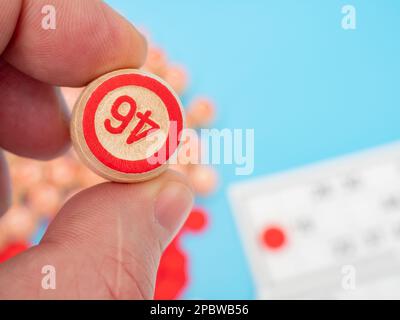 Bingo gioco da tavolo. Botti di legno con numeri in mano. Primo piano. Foto Stock