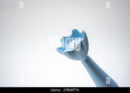 Piccolo frullatore a immersione in plastica con lama in metallo. Primo piano ripresa in studio, isolata su sfondo bianco. Foto Stock