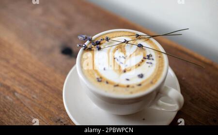 Latte di lavanda con caffè al cuore in tazza bianca Foto Stock