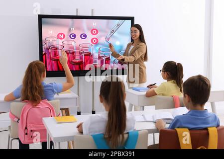 Insegnante che usa una lavagna interattiva in aula durante la lezione Foto Stock