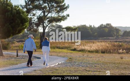 coppia anziana che cammina sul lungomare una giornata di sole Foto Stock