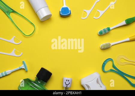 Telaio di detergenti per lingua e prodotti per la cura dei denti su fondo giallo, piatto. Spazio per il testo Foto Stock