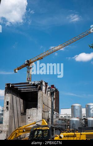 Vecchio edificio di appartamenti in fase di demolizione in una città svizzera in Europa. Giorno estivo soleggiato, escavatori e gru, nessuna gente. Foto Stock