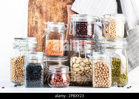 Legumi e fagioli in vasi. Lenticchie gregge, ceci, fagioli comuni, soia, edamame, piselli. Dieta sana, proteine vegane, micronutrienti e Foto Stock