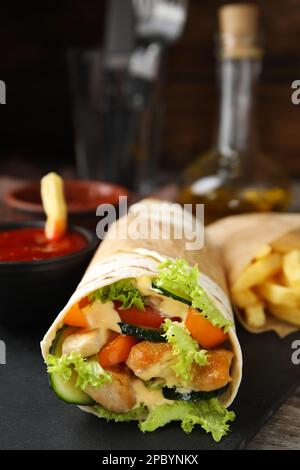 Delizioso shawarma di pollo su piatto di ardesia, primo piano Foto Stock