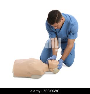 Medico in uniforme praticando il primo soccorso sul manichino su sfondo bianco Foto Stock