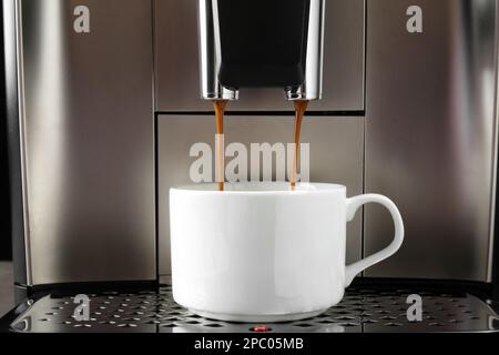 Moderna macchina da caffè espresso che versa il caffè in una tazza e in un  primo piano Foto stock - Alamy