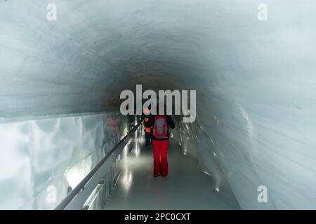 Jungfraujoch, Canton Berna, Svizzera, 11 febbraio 2023 i pedoni attraversano il sistema di tunnel all'interno del palazzo del ghiaccio Foto Stock