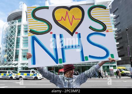 Londra, Regno Unito. 11 marzo, 2023. Un protester tiene un cartello che dice 'SOS NHS', con l'ospedale dell'unità Centrale Abitacolo sullo sfondo, come personale del Servizio sanitario Nazionale e su Foto Stock