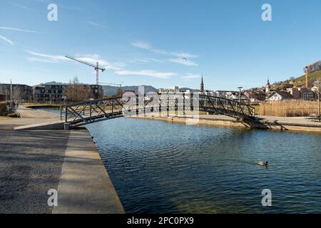 Unteraegeri, Svizzera, 20 febbraio 2023 piccolo ponte pedonale attraverso un canale sul lago Aegerisee Foto Stock