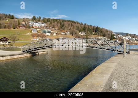 Unteraegeri, Svizzera, 20 febbraio 2023 piccolo ponte pedonale attraverso un canale sul lago Aegerisee Foto Stock