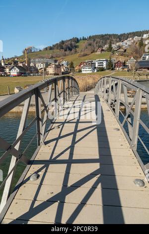 Unteraegeri, Svizzera, 20 febbraio 2023 piccolo ponte pedonale attraverso un canale sul lago Aegerisee Foto Stock