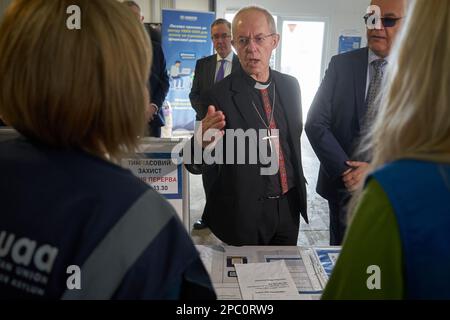 Bucarest, Romania. 13th Mar, 2023: Il Reverendo Justin Welby (C), Arcivescovo di Canterbury, parla allo staff dell'UNHCR durante la visita al centro integrato dell'UNHCR per i rifugiati ucraini a causa dell'invasione russa dell'Ucraina, presso il centro espositivo Romexpo. Durante la visita di tre giorni in Romania, l Arcivescovo avrà diversi incontri di alto livello con sua Maestà Margareta, Custode della Corona rumena, il Patriarca rumeno Daniele e i politici. Credit: Lucian Alecu/Alamy Live News Foto Stock