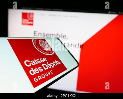 Cellulare con logo di Caisse des depots et Consignations (CDC) sullo schermo di fronte al sito web. Messa a fuoco sul lato destro del display del telefono. Foto Stock