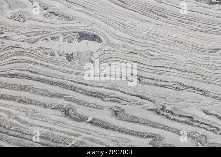 Struttura di granito grigio fumo con venature, strisce e macchie diagonali. Foto Stock