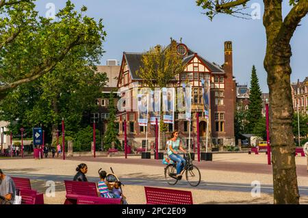 Una donna in bicicletta a Museum Square, Amsterdam, Paesi Bassi Foto Stock