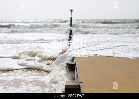 Boscombe, Bournemouth, Dorset, Regno Unito, 13th marzo 2023, Meteo. Forti venti e condizioni tempestose sul lungomare al mattino, creando onde spumose e schiumose sulla spiaggia. Credit: Paul Biggins/Alamy Live News Foto Stock
