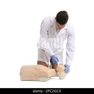 Medico in uniforme praticando il primo soccorso sul manichino su sfondo bianco Foto Stock