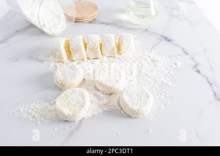 formaggio fresco fatto in casa su un tavolo di marmo bianco in farina Foto Stock