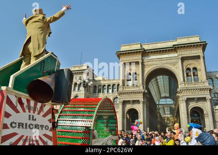 Una folla festosa vestita da carnevale guarda uno spettacolo di circo 'il Criceto' (criceto) durante la celebrazione del Carnevale in Piazza Duomo a Milano in una giornata di sole. Foto Stock