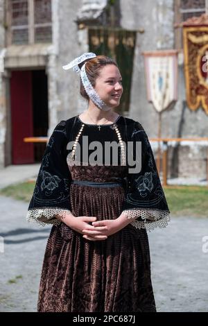 Plonévez-Porzay, Francia - Agosto 29 2021: Giovane donna in abito bretone tradizionale durante il perdono della Cappella Sainte-Anne-la-Palud. Foto Stock