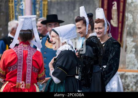 Plonévez-Porzay, Francia - 29 2021 agosto: Gruppo di persone in abiti tradizionali bretoni durante il perdono della Cappella Sainte-Anne-la-Palud. Foto Stock