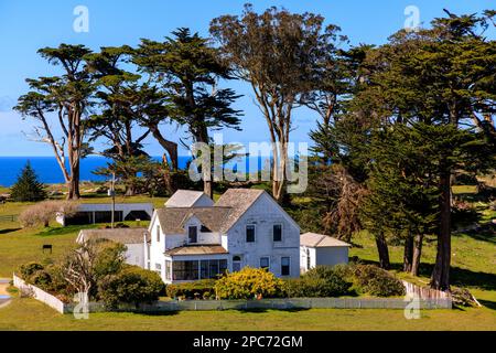 Storica casa bianca e alberi alti sul ranch rustico nella California costiera Foto Stock