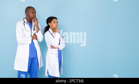 Pensivo sicuro medici afroamericani in uniforme bianca guardando lo spazio copia e pensare, panorama Foto Stock