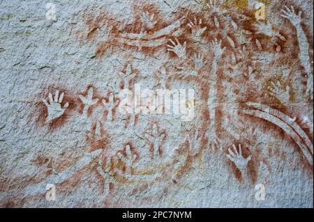 Arte rupestre aborigena, stencil art, di circa 2000 anni, con raffigurazioni di mani, boomerang, ossa di roccia wallaby e piedi emu, Galleria d'Arte Foto Stock