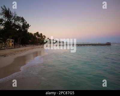 Spiaggia serale. Calma sul mare. Ci sono molte palme sulla spiaggia di sabbia bianca. Crepuscolo. Bella stagione. Cartolina, banner, pubblicità di tra Foto Stock