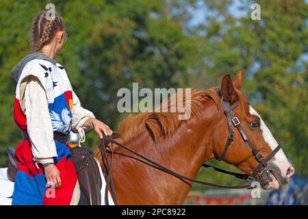 Luzarches, Francia - 13 2019 ottobre: Giovane donna vestita come cavaliere sul suo cavallo durante l'annuale festa 'Médiévales'. In autunno, in molti medievali Foto Stock