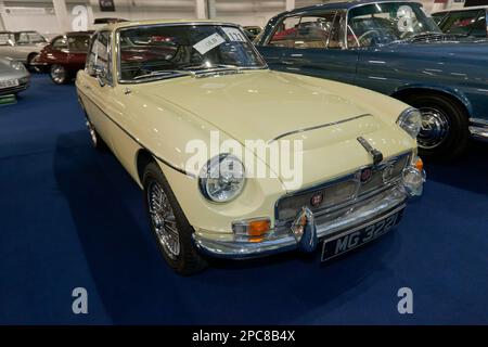 Vista frontale a tre quarti di una 1968, MGC GT, parte dell'asta London Classic Car 2023 ad Olympia, Londra Foto Stock