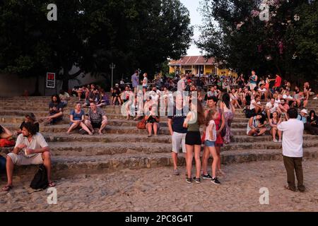 Turisti seduti sulle scale in una strada molto popolare angolo Casa de la Musica a Trinidad con piccoli ristoranti. Cuba Foto Stock