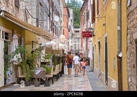 Turisti che camminano in vicolo con ristoranti nel centro storico della città di Pola / Pola, Istria County, Croazia Foto Stock