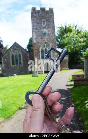 Mano maschile che tiene la chiave per Willand Parish Church, Devon, Regno Unito Foto Stock