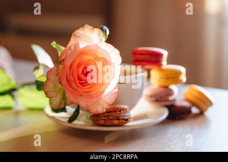Biscotti di rosa e amaroni e fragola dolce su sfondo blu. Piccoli Macarons dolci francesi . buon giorno per le madri, buongiorno Foto Stock