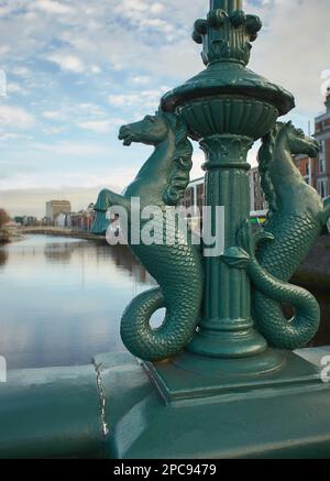 Immagine del fiume Liffey Dublino dal Ponte di Grattan con la statua ornamento del ponte di Sea Horses in primo piano . Foto Stock