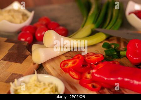 Una varietà di prodotti alimentari tra cui carni e altri ingredienti su taglieri prima di fare la pizza Foto Stock