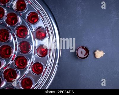 Concetto di comunione - il vino e i simboli del pane di Gesù Cristo sangue e corpo con la Sacra Bibbia. Pasqua pasquale e concetto di cena del Signore. Foto Stock