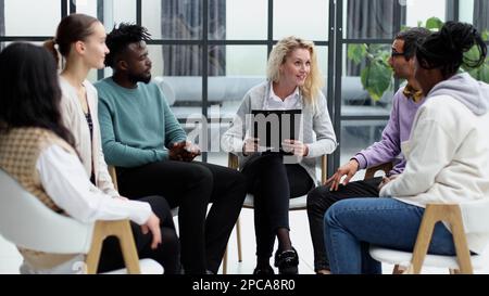conduce una formazione aziendale con un gruppo di giovani. Foto Stock