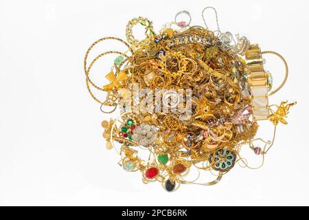 Ripresa orizzontale di una pila di gioielli in oro con spazio copia su sfondo bianco. Foto Stock