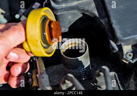 Aprire manualmente un tappo del bocchettone di rifornimento dell'olio della vettura Foto Stock