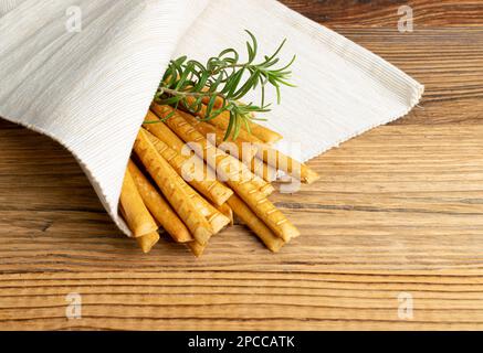 Bastoncini di pane sul tavolo del ristorante, grissini salati, Grissini croccanti, Pretzel fatte in casa a secco, bastoncino di pane su sfondo rustico in legno Foto Stock