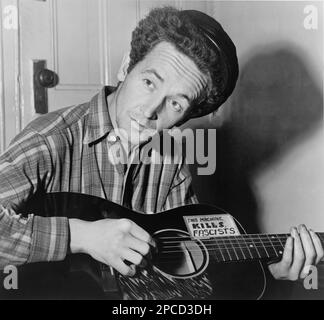 1943 , 8 marzo , USA : il celebre cantante country americano WOODY GUTHRIE (nato Woodrow Wilson Guthrie , 1912 - 1967 ). Foto di al Aumuller . È meglio conosciuto come cantautore e musicista folk americano, la cui eredità musicale include centinaia di canzoni politiche, tradizionali e per bambini, ballate e opere improvvisate. Si esibì spesso con lo slogan "This Machine Kills Fascists" visualizzato sulla chitarra. La sua canzone più conosciuta è probabilmente ' This Land is Your Land '- CHITARRA - chitarrista - chitarrista - MUSICA - ROCK - MUSICA LEGGGERA - ritratto - ritrato - musicista - musi Foto Stock